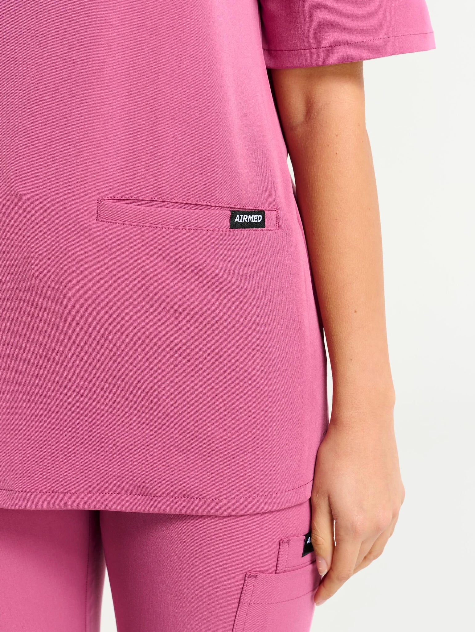 back view of red violet v neck scrub top